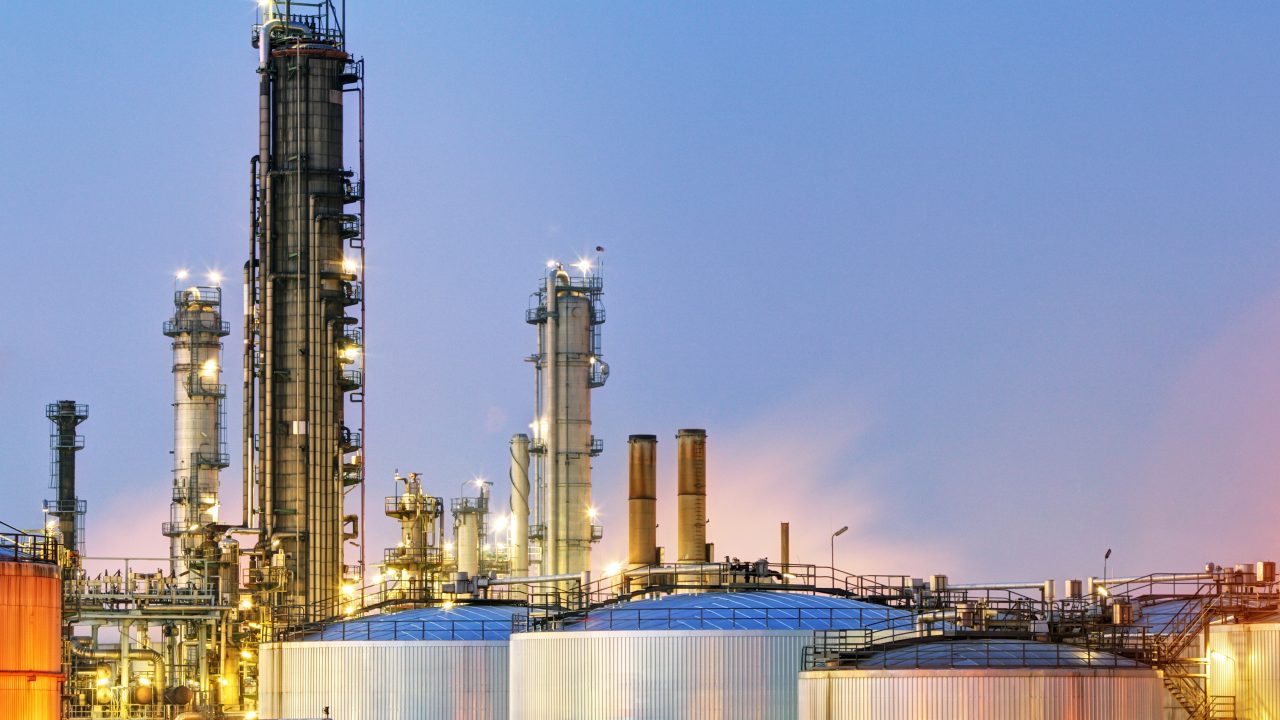 Oil and gas refinery at dusk with flameproof gas detection needs.