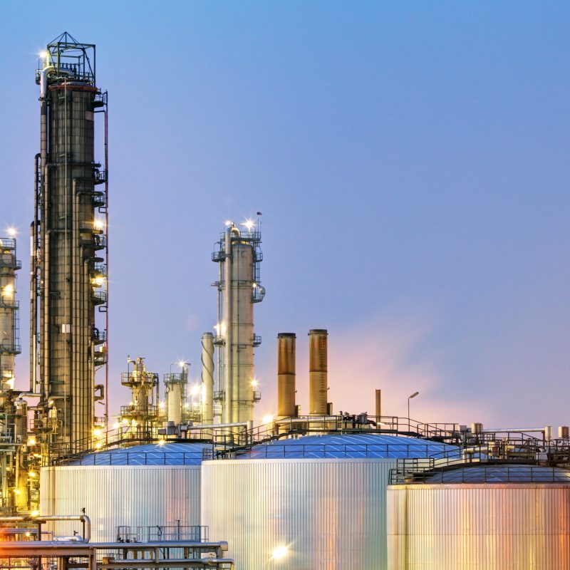 Oil and gas refinery at dusk with flameproof gas detection needs.